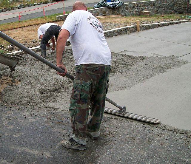 Photo of concrete worker using a bull float.